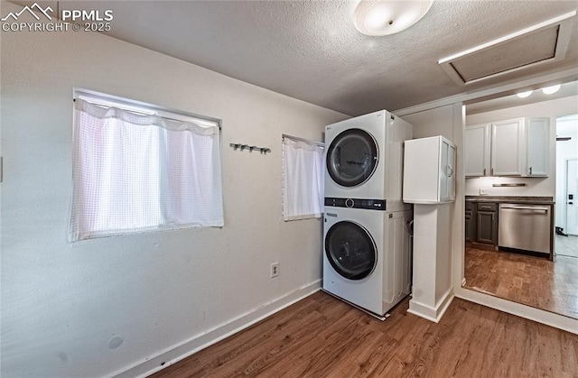 2830 W Kiowa St, Colorado Springs, CO 80904 - laundry area with estacked washer and dryer, attic access, wood finished floors, and a textured ceiling