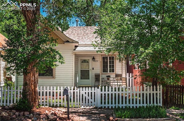 2830 W Kiowa St, Colorado Springs, CO 80904 - view of front of property with a shingled roof and a fenced front yard