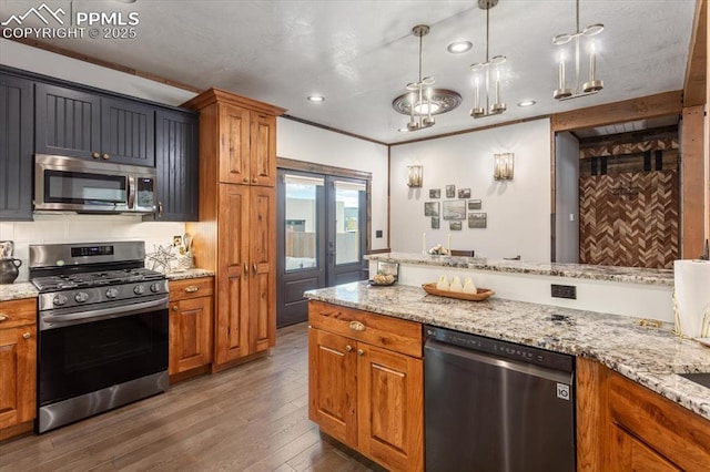 1124 E Poncha Ave, Salida, CO 81201 - kitchen with stainless steel appliances, brown cabinetry, hardwood / wood-style floors, light stone counters, and recessed lighting