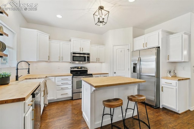3748 Reindeer Cir, Colorado Springs, CO 80922 - kitchen featuring butcher block counters, appliances with stainless steel finishes, a kitchen island, white cabinets, and a sink