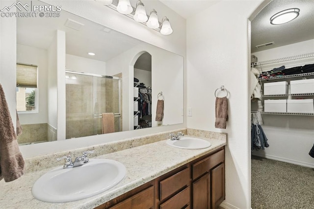 3748 Reindeer Cir, Colorado Springs, CO 80922 - bathroom with a walk in closet, double vanity, and a shower stall