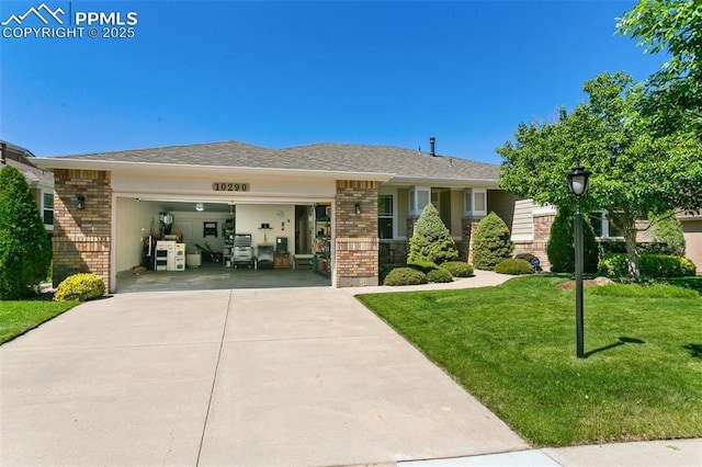 10290 Peach Blossom Trl, Colorado Springs, CO 80920 - view of front of home featuring brick siding, a garage, concrete driveway, and a front yard