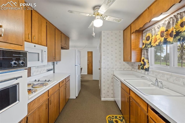 2043 Patrician Way, Colorado Springs, CO 80909 - kitchen featuring white appliances, wallpapered walls, a sink, light countertops, and brown cabinets