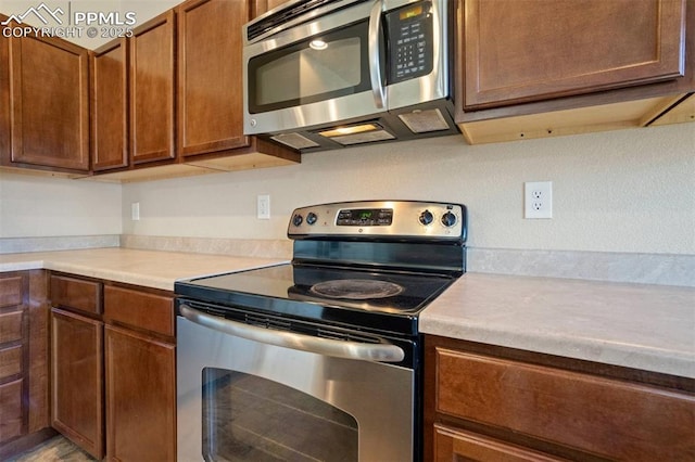 2305 Reed Grass Way, Colorado Springs, CO 80915 - kitchen featuring stainless steel appliances, light countertops, and brown cabinets