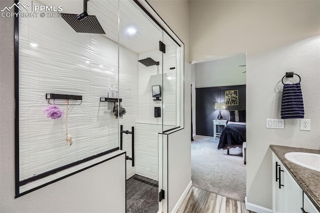 8084 Cinnamon Ct, Colorado Springs, CO 80927 - ensuite bathroom featuring tiled shower, vanity, wood finished floors, and baseboards