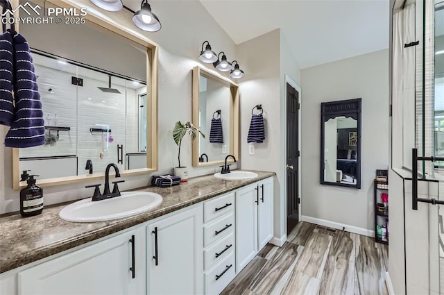 8084 Cinnamon Ct, Colorado Springs, CO 80927 - full bathroom with double vanity, a shower stall, wood finished floors, and baseboards