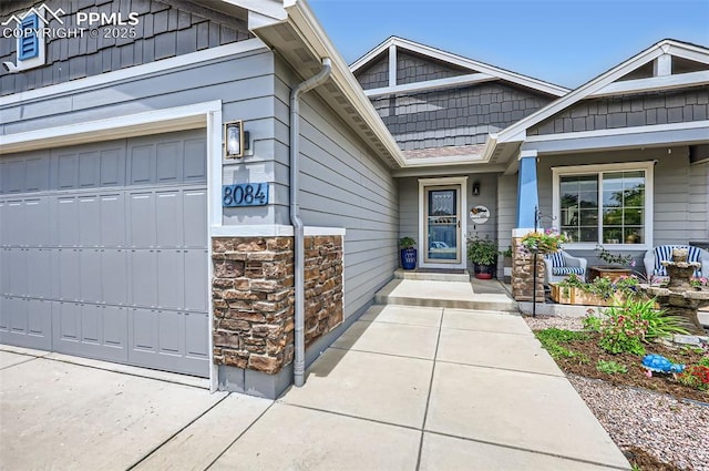 8084 Cinnamon Ct, Colorado Springs, CO 80927 - view of exterior entry with stone siding, an attached garage, and covered porch