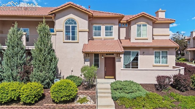 4710 Sand Mountain Pt, Colorado Springs, CO 80923 - mediterranean / spanish-style home with stucco siding, a tiled roof, and a chimney