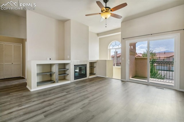 4710 Sand Mountain Pt, Colorado Springs, CO 80923 - unfurnished living room with wood finished floors, ceiling fan, and a tile fireplace