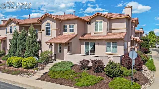 4710 Sand Mountain Pt, Colorado Springs, CO 80923 - mediterranean / spanish home with a tiled roof, stucco siding, and a chimney