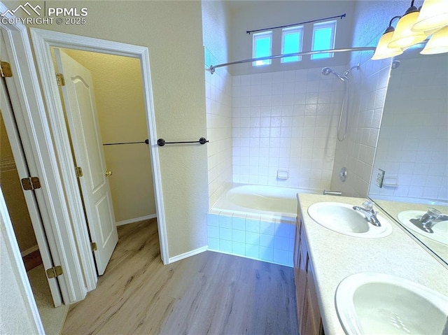 4710 Sand Mountain Pt, Colorado Springs, CO 80923 - bathroom with wood finished floors, tiled shower / bath, and double vanity