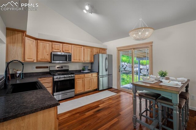 4125 Cricket Ct, Colorado Springs, CO 80918 - kitchen with appliances with stainless steel finishes, dark countertops, dark wood-style floors, a chandelier, and light brown cabinetry