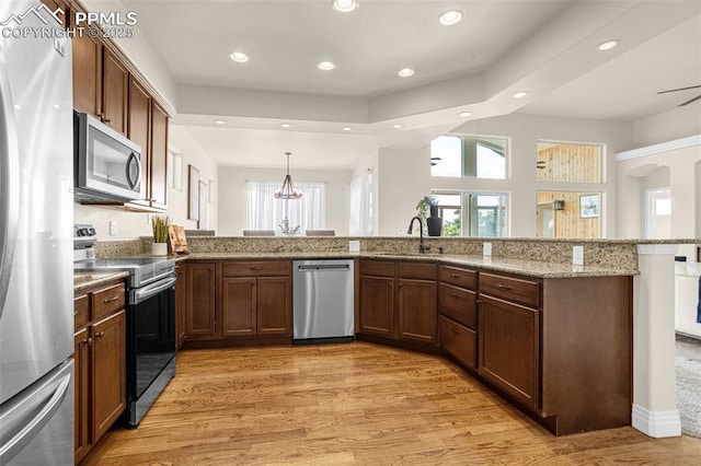 16255 Ridge Run Dr, Colorado Springs, CO 80908 - kitchen with appliances with stainless steel finishes, light wood finished floors, recessed lighting, light stone countertops, and hanging light fixtures