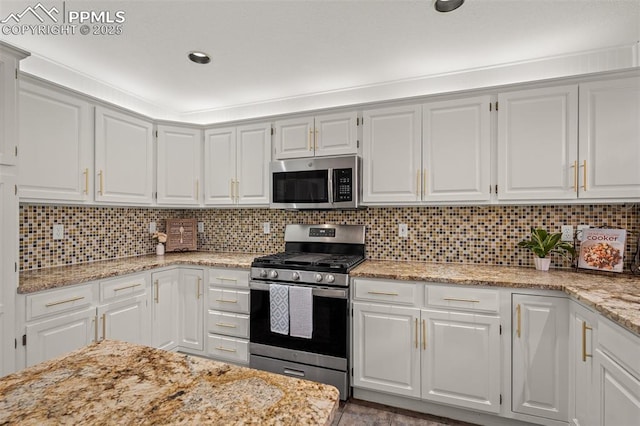 206 Luxury Ln, Colorado Springs, CO 80921 - kitchen featuring appliances with stainless steel finishes, white cabinetry, and decorative backsplash