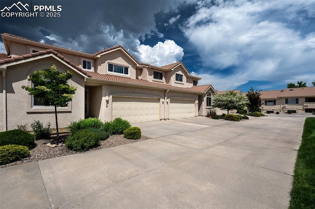 206 Luxury Ln, Colorado Springs, CO 80921 - view of front of house featuring driveway, stucco siding, a garage, and a tile roof