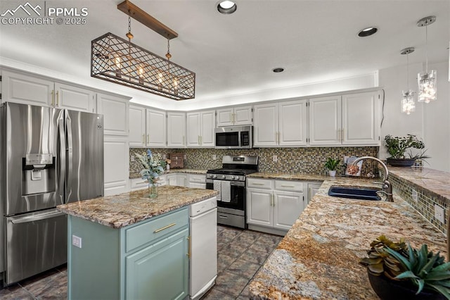 206 Luxury Ln, Colorado Springs, CO 80921 - kitchen with appliances with stainless steel finishes, decorative backsplash, a kitchen island, decorative light fixtures, and white cabinets