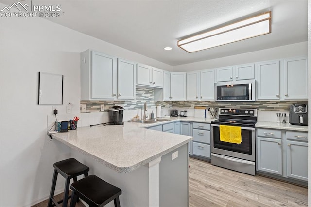 1749 Victorian Pt, Colorado Springs, CO 80905 - kitchen with stainless steel appliances, a peninsula, backsplash, a breakfast bar area, and recessed lighting
