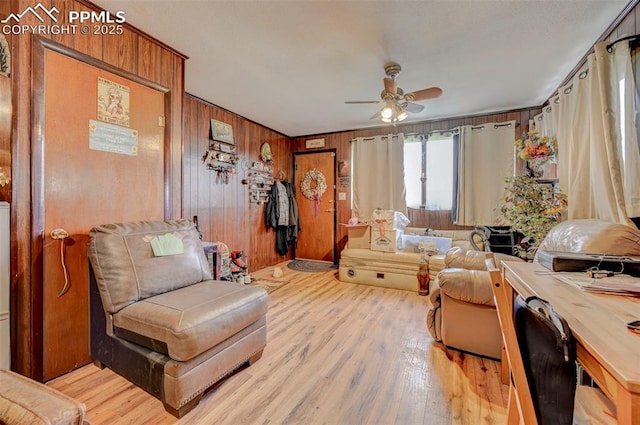 128 W Eaton Ave, Cripple Creek, CO 80813 - living area featuring ceiling fan, light wood-type flooring, and wooden walls