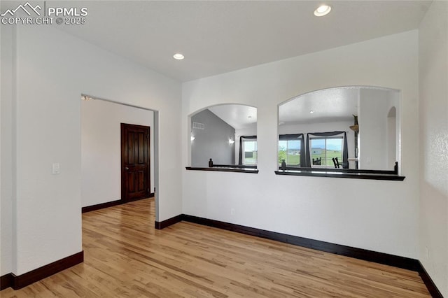 11354 Mckissick Rd, Peyton, CO 80831 - empty room with light wood-style flooring, arched walkways, and recessed lighting