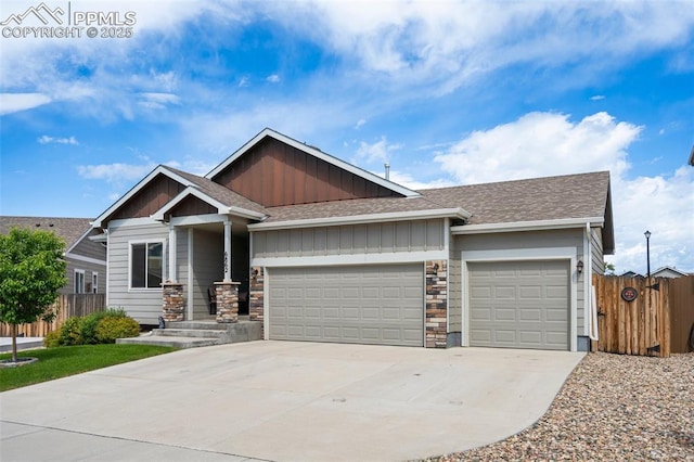 6862 Simcoe Dr, Colorado Springs, CO 80925 - view of front of house featuring an attached garage, a shingled roof, driveway, board and batten siding, and stone siding