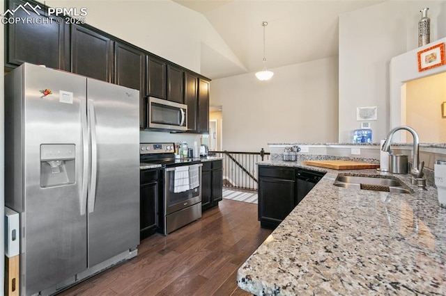 6862 Simcoe Dr, Colorado Springs, CO 80925 - kitchen with stainless steel appliances, a sink, dark wood-type flooring, hanging light fixtures, and light stone countertops