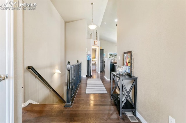 6862 Simcoe Dr, Colorado Springs, CO 80925 - hallway with an upstairs landing, dark wood finished floors, baseboards, and vaulted ceiling