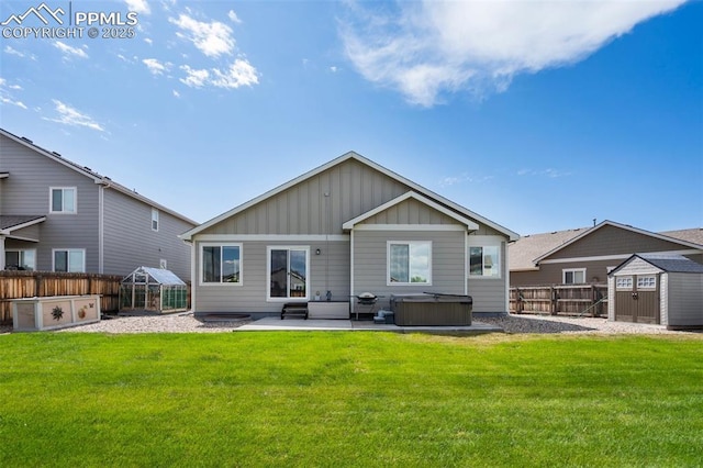 6862 Simcoe Dr, Colorado Springs, CO 80925 - back of house with board and batten siding, a hot tub, and a patio
