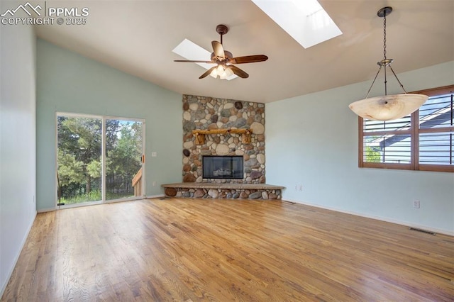 55 Misty Creek Dr, Monument, CO 80132 - unfurnished living room featuring a skylight, wood finished floors, ceiling fan, a fireplace, and high vaulted ceiling