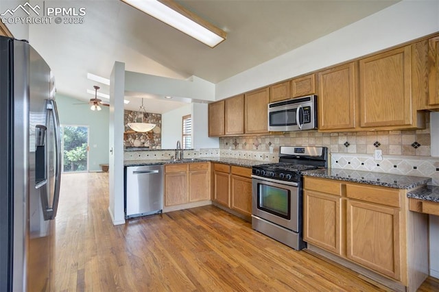 55 Misty Creek Dr, Monument, CO 80132 - kitchen with appliances with stainless steel finishes, lofted ceiling, healthy amount of natural light, ceiling fan, and tasteful backsplash