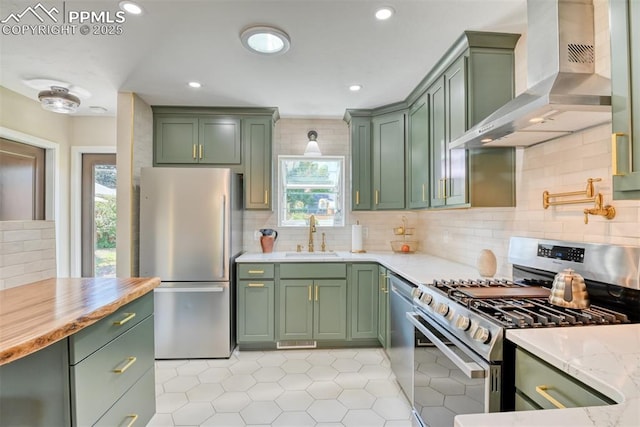 1445 N Foote Ave, Colorado Springs, CO 80909 - kitchen featuring green cabinetry, stainless steel appliances, wall chimney range hood, light tile patterned floors, and healthy amount of natural light