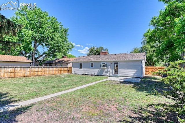 1445 N Foote Ave, Colorado Springs, CO 80909 - rear view of house with a fenced backyard, a patio, and a chimney