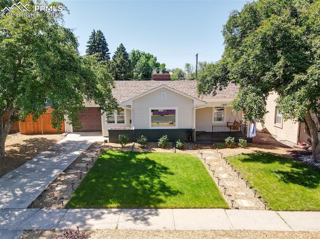 1445 N Foote Ave, Colorado Springs, CO 80909 - view of front facade with a porch, concrete driveway, a front yard, an attached garage, and roof with shingles