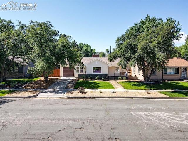 1445 N Foote Ave, Colorado Springs, CO 80909 - obstructed view of property featuring concrete driveway, a front lawn, and a garage