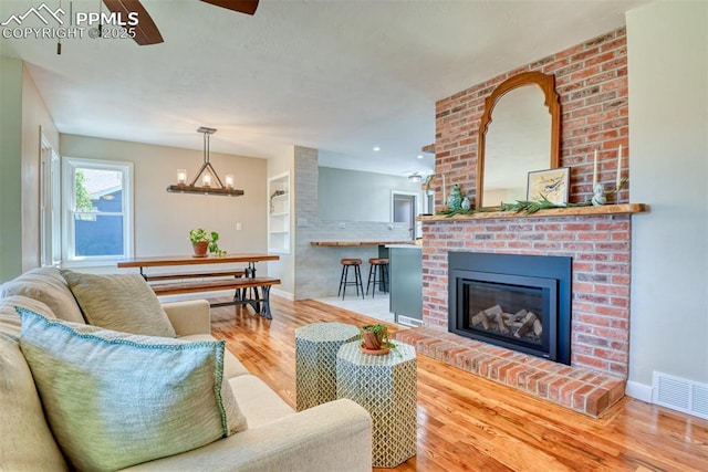 1445 N Foote Ave, Colorado Springs, CO 80909 - living room with wood finished floors, ceiling fan, and a fireplace