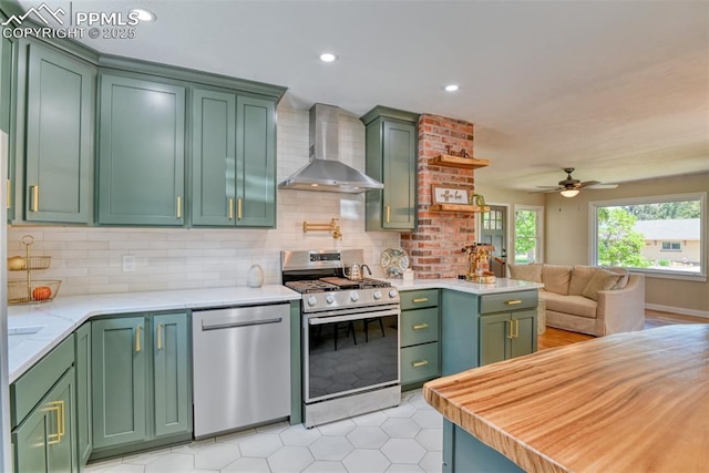 1445 N Foote Ave, Colorado Springs, CO 80909 - kitchen with stainless steel appliances, wall chimney exhaust hood, green cabinets, tasteful backsplash, and recessed lighting