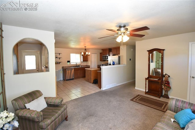 719 Lansing Dr, Colorado Springs, CO 80909 - living room with a ceiling fan, a chandelier, light carpet, and light tile patterned floors