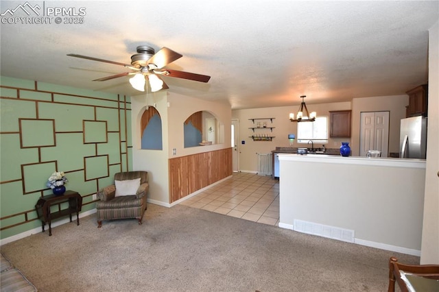 719 Lansing Dr, Colorado Springs, CO 80909 - living room with a chandelier, ceiling fan, light colored carpet, and light tile patterned floors