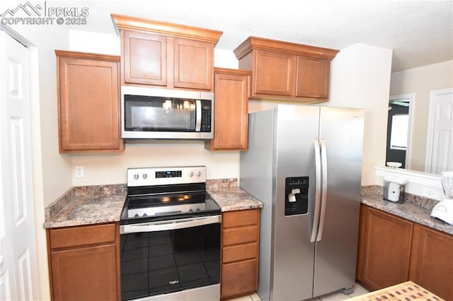 719 Lansing Dr, Colorado Springs, CO 80909 - kitchen with stainless steel appliances, brown cabinets, and light stone counters