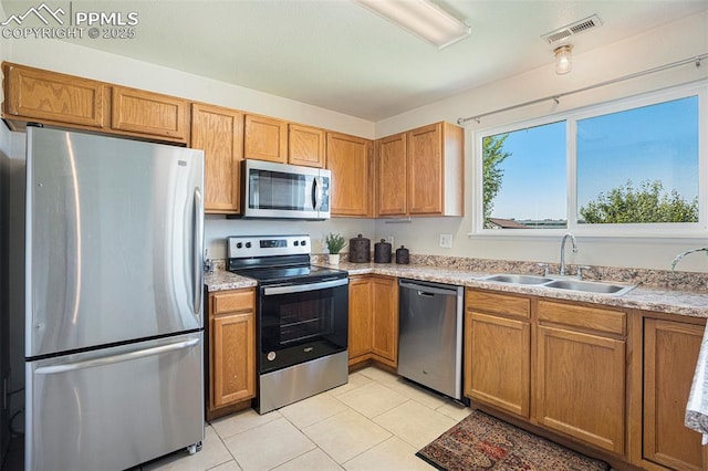 4585 W Jet Wing Cir, Colorado Springs, CO 80916 - kitchen with appliances with stainless steel finishes, a sink, light tile patterned floors, and light countertops