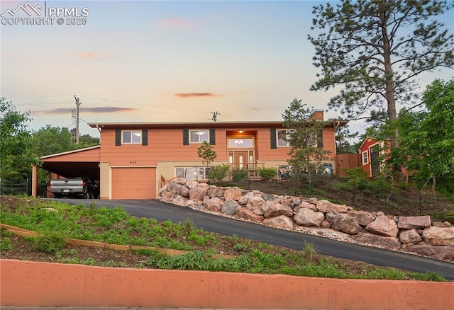 443 E Fountain Pl, Manitou Springs, CO 80829 - split foyer home featuring driveway, a garage, a chimney, and brick siding