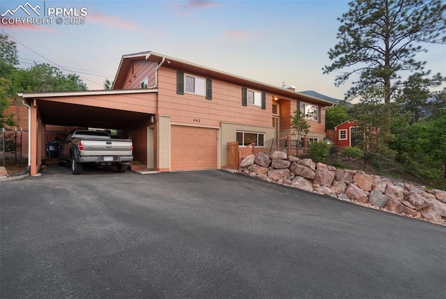 443 E Fountain Pl, Manitou Springs, CO 80829 - view of front facade featuring a carport, a garage, brick siding, and asphalt driveway