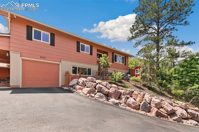 443 E Fountain Pl, Manitou Springs, CO 80829 - split foyer home with a garage, brick siding, and asphalt driveway