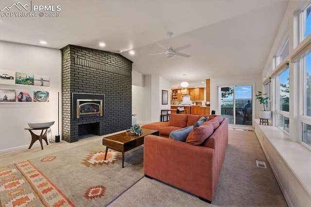 78 Raven Hills Ct, Colorado Springs, CO 80919 - carpeted living area with lofted ceiling, a ceiling fan, and a brick fireplace