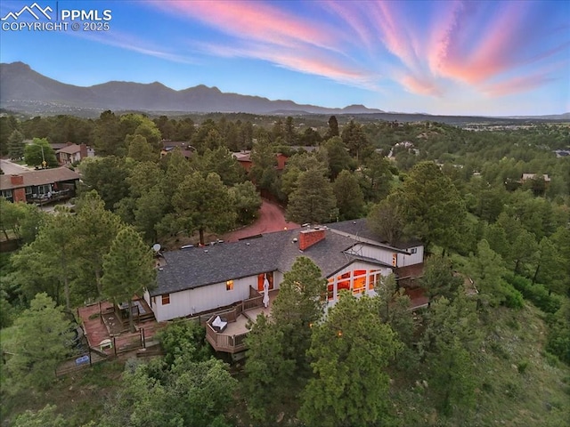 78 Raven Hills Ct, Colorado Springs, CO 80919 - aerial view of property and surrounding area featuring a heavily wooded area and a mountainous background