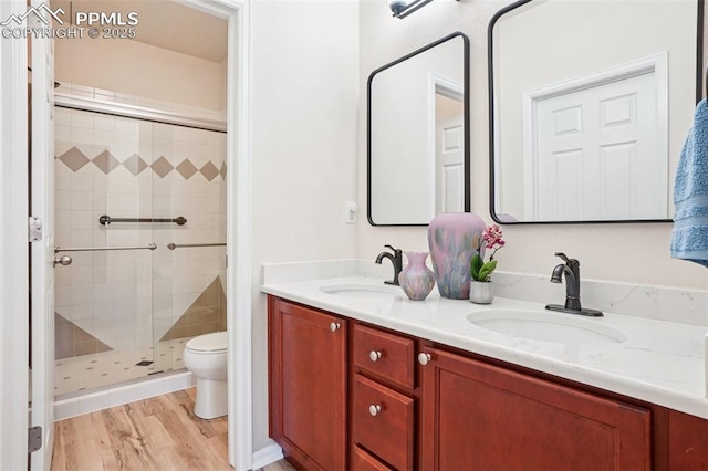 7845 Morning Dew Rd, Colorado Springs, CO 80908 - bathroom with a shower stall, double vanity, and wood finished floors