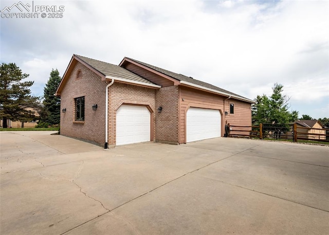1660 Old Antlers Way, Monument, CO 80132 - view of property exterior featuring concrete driveway, an attached garage, and brick siding