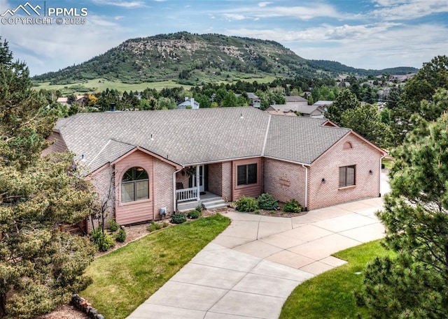 1660 Old Antlers Way, Monument, CO 80132 - single story home with brick siding, a mountain view, and concrete driveway