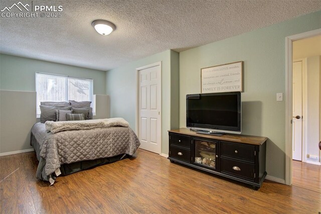 6055 Fescue Dr, Colorado Springs, CO 80923 - bedroom with wood finished floors and a textured ceiling