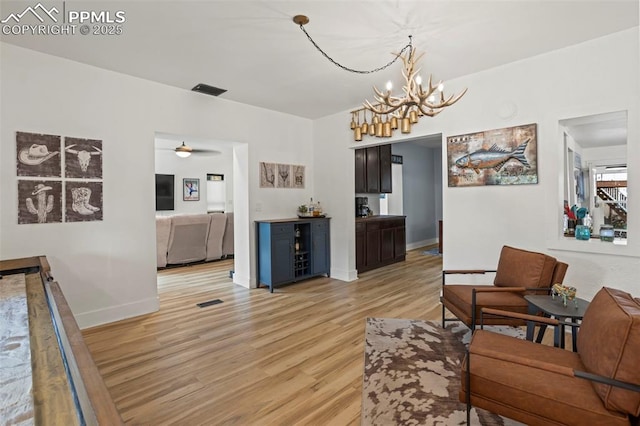 1607 W Pikes Peak Ave, Colorado Springs, CO 80904 - living room with light wood finished floors, a chandelier, and a ceiling fan