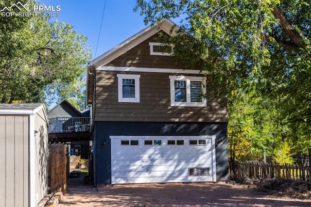 1607 W Pikes Peak Ave, Colorado Springs, CO 80904 - view of front of home with a garage, driveway, a wooden deck, and an outdoor structure